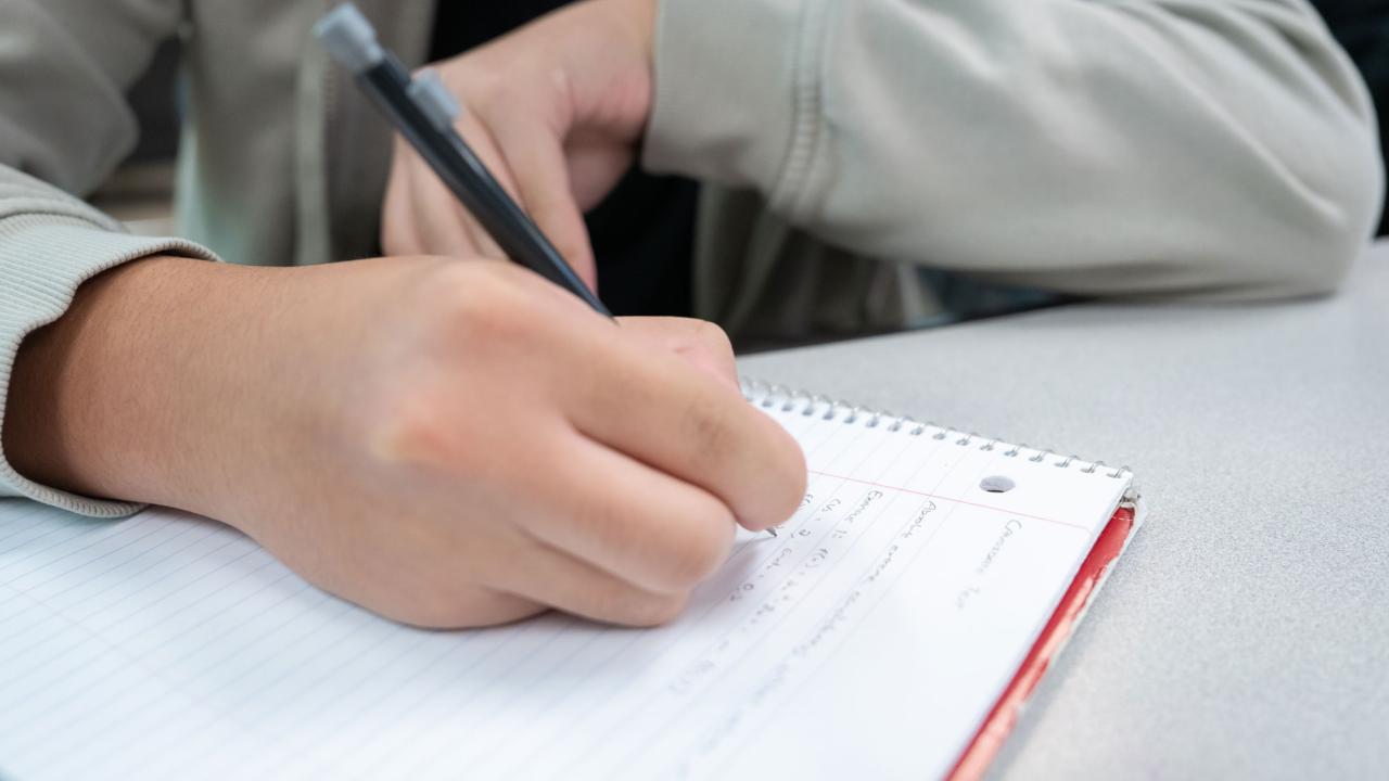 student works on math problem in notebook