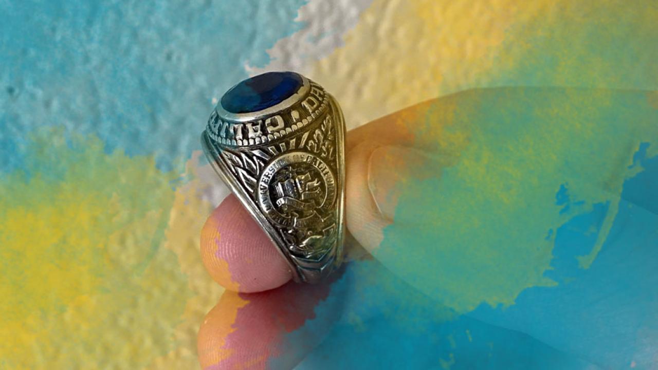 close up of a hand holding a class ring