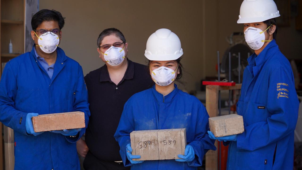 Students and professor display wildfire-resistant bricks