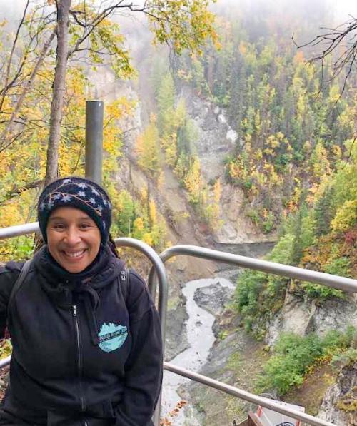 Woman on platform above river canyon