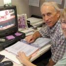 Photo: man and woman in front of computer looking at camera