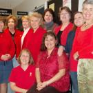 Red-dressers, from left above are: Lynda Jones, Vita Simonsen, Cindy Dufern, Janie Guhin, Mary White, Terry Antonelli, Pam Self, Merlyn Potters; and seated, Melissa Lovejoy and Maria Saldana-Seibert.