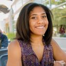Woman sitting at a table smiling at the camera
