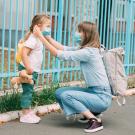 Girl and nanny in masks, outdoors