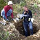 Photo: two women out doors examining soil in bag