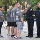 UC Davis Police Chief Joe Farrow and Davis Police Chief Darren Pytel hand off the torch to runners.