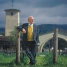 Man leaning on fence with tower in background