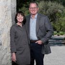 Woman and man standing next to an adobe wall outside