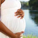 Cropped photo of a pregnant woman standing near a lake