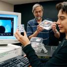 Graduate student Maria Ferrua looks at marbles used to model the air flow around objects, like different types of fruit. R. Paul Singh is shown holding  strawberry cartons that are currently available commercially. He is using computer models to