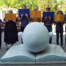 Staff members pose with blue and gold books.