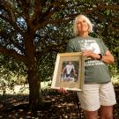 Nori Reinert holds a photo of her late husband William at the Arboretum