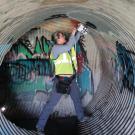 Woman works in a drainpipe