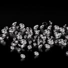 A scattering of bright clear crystals against a black background.