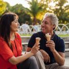 Couple having ice cream cones at park