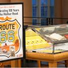 Museum Route 66 exhibit with tall sign and lit glass display cases
