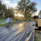 Students cover ground with weed fabric.