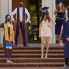 Students in grad caps and face coverings pose for a photo.