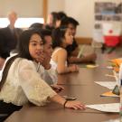 A student in a crowded room reaches for a paper at UC Davis. 