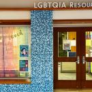 LGBTQIA Resource Center window with rainbow curtain, wooden double doors, blue mosaic tiles