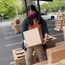 A student loads boxes of food for delivery to seniors during the pandemic.