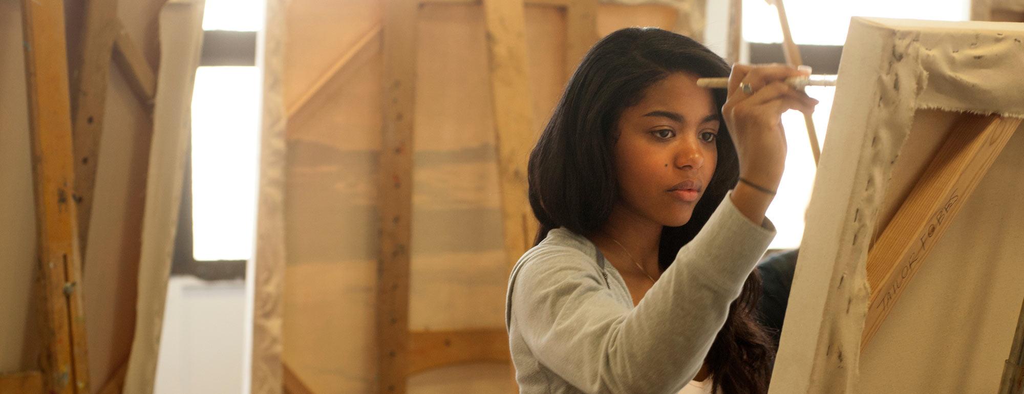 A female student painting on a canvas