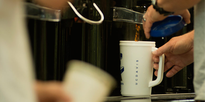  coffee urns with someone filling up a mug