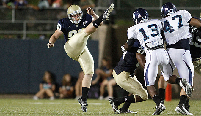 Football punter kicks high in the air