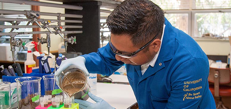 Young man leaning over and working on a lab project