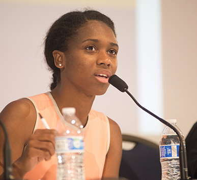 A woman speaks into a microphone