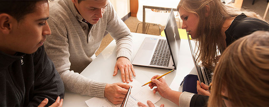 A number of people intently working around a table