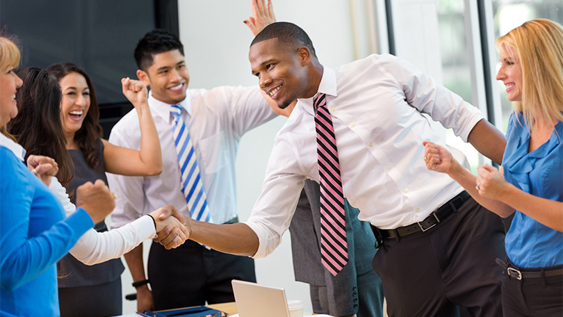 a man receives congratulations at a meeting