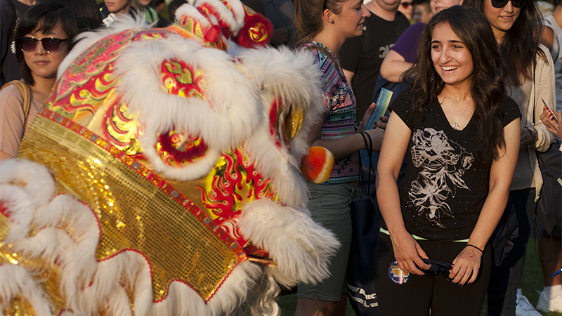 A lion dancer surprises a student